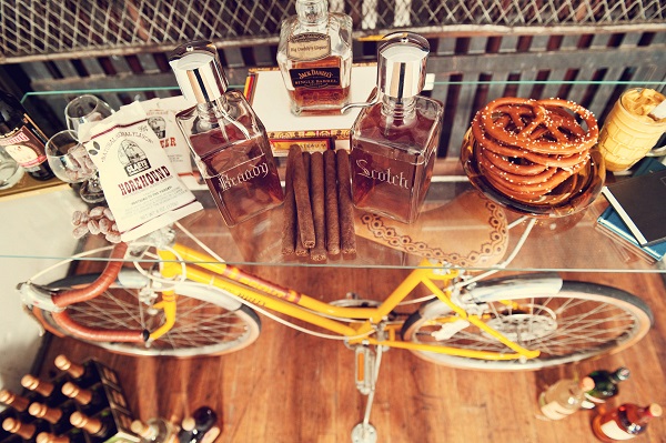 Whiskey table at wedding with old bike holding it up.