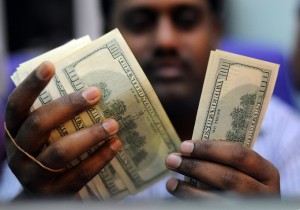 Black man counting 100 dollar bills.
