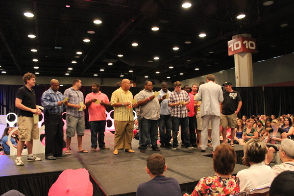 Groom's lined up on stage at bridal show.