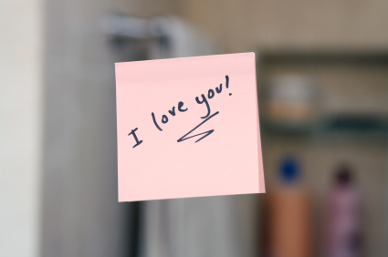 I love you written on a post-it note attached to a mirror.