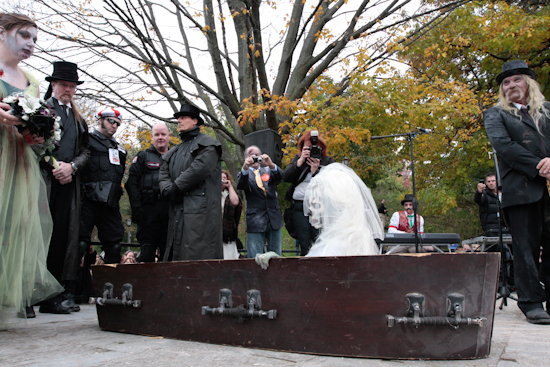 Zombie bride getting out of coffin during wedding ceremony.